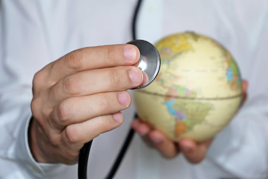 Doctor holding stethoscope over globe
